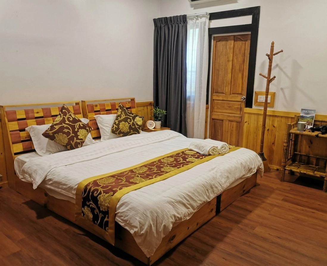 Deluxe Double or Twin Room at Ocean Vista Maldives with wooden bed frame, decorative cushions and warm island styling